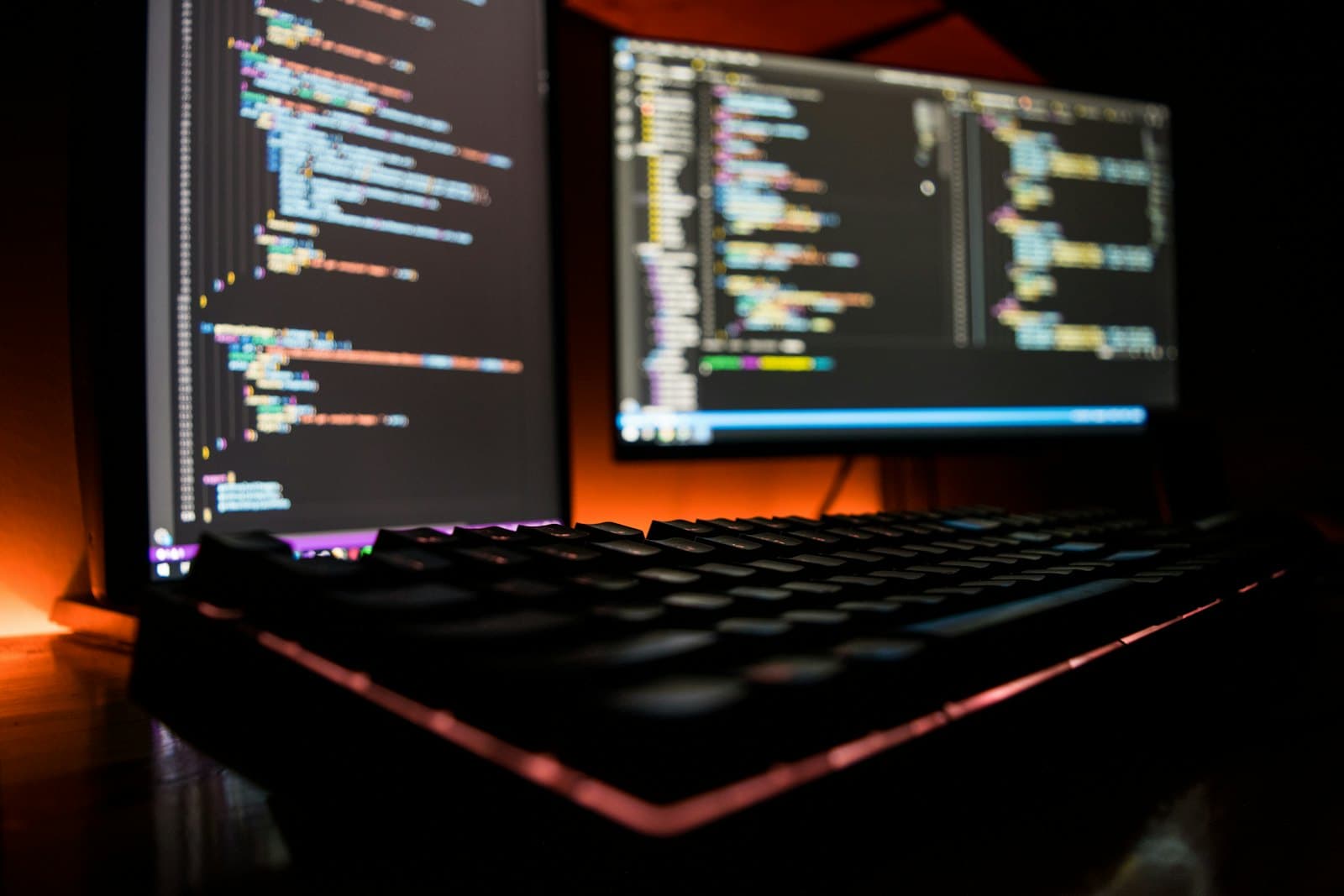 Code and logs on monitors in a darkened operations room